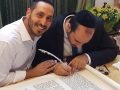 יעקב טייב בכתיבת אותיות אחרונות של ספר תורה